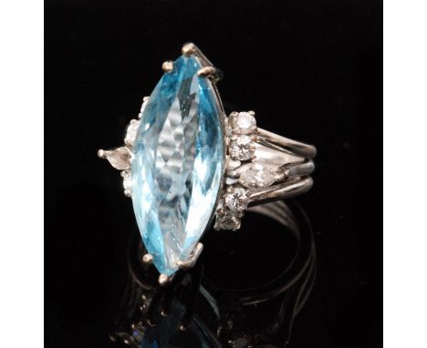 An 18ct white gold, aquamarine and diamond dress ring, the marquise cut aquamarine bordered by four brilliant cut diamonds an