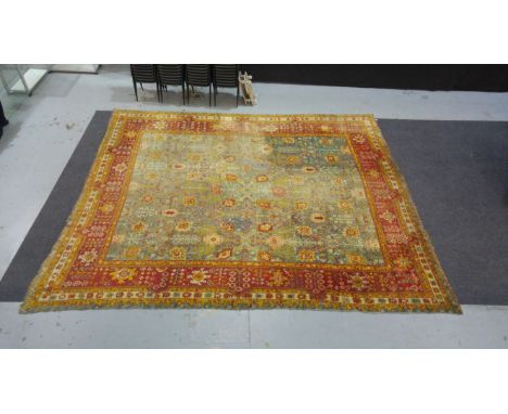 Amended description - A large early 20th Century Turkey carpet in traditional design with interspaced flower heads on a pale 
