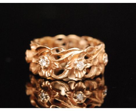 A 14ct floral decorated pierced ring detailed with seven individually claw set diamonds, ring size M. 