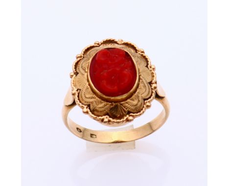 Yellow gold ring, 585/000, with cut red coral. Ring with an oval contoured edge with engraving and a twisted edge. The bezel 