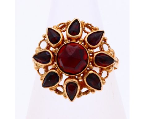 Yellow gold ring, 585/000, with garnet. Ring with a large rosette set with a round faceted garnet in the middle and around it