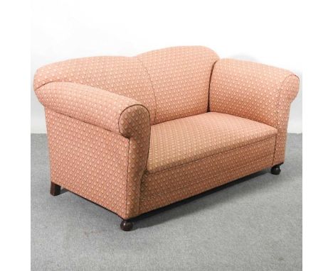 A 1920's salmon pink upholstered two seater drop end sofa, on bun feet163w x 78d x 82h cm