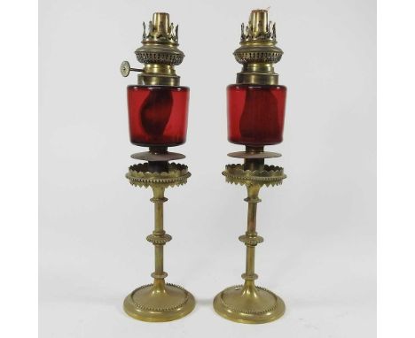 A pair of ruby glass peg oil lamps, stamped Brevetes 1878, 36cm high (2)