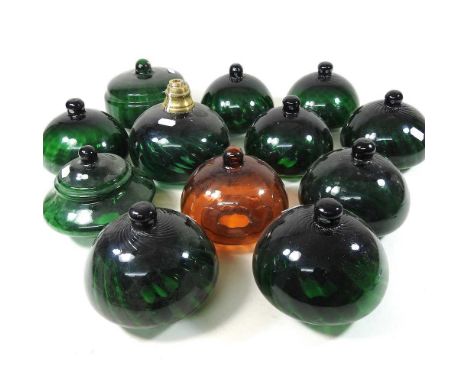 A collection of green glass oil lamp fonts, widest 15cm