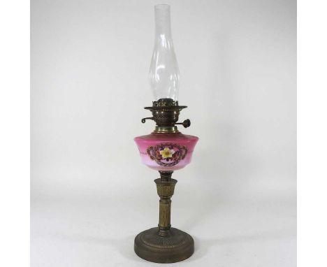A brass oil lamp base, the pink glass reservoir painted with flowers, 41cm high, with chimney