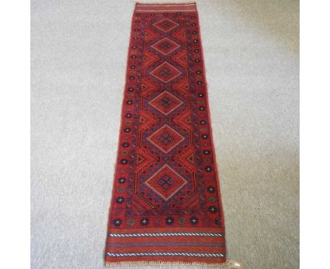 A meshwani runner, with six central medallions, on a red ground, 252 x 60cm