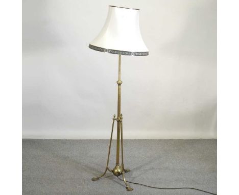 An early 20th century brass telescopic standard lamp, on a splayed base, with shade. To the bulb fitting, it will extend up t