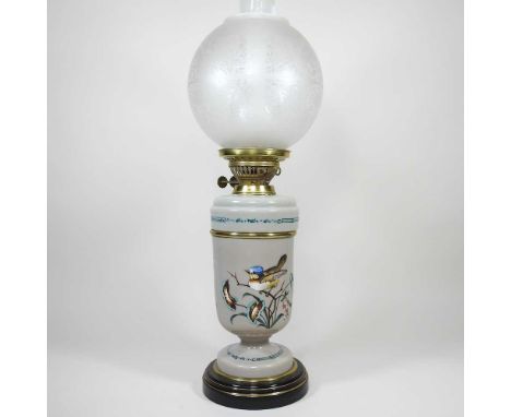 A French opaline glass oil lamp, decorated with a bird, with an opaque glass shade, 55cm high overall