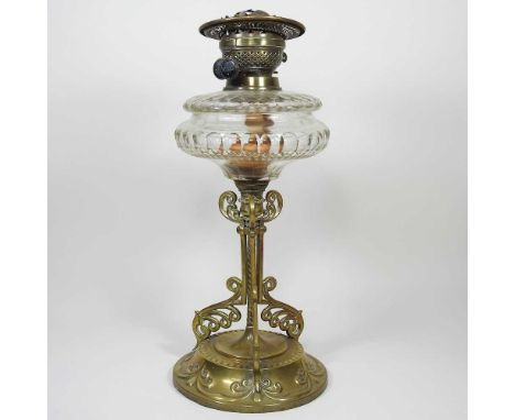 A brass and glass oil lamp base, on an ornate scrolled base, 43cm high