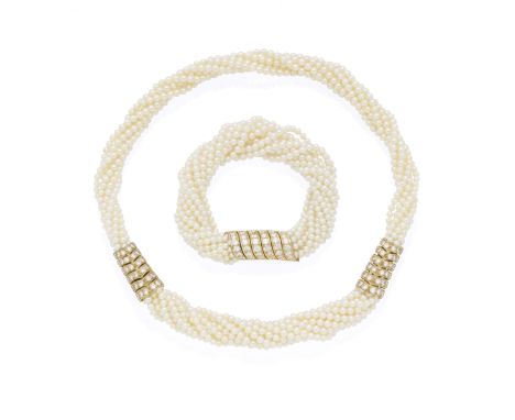 CARTIER: DIAMOND AND SEED PEARL TORSADE NECKLACE AND BRACELET SUITE, 1988Each comprising eleven rows of seed pearls, the cyli