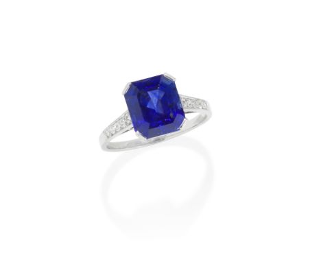 ART DECO SAPPHIRE AND DIAMOND RING, CIRCA 1920The step-cut sapphire, weighing 5.19 carats, between graduating brilliant-cut d