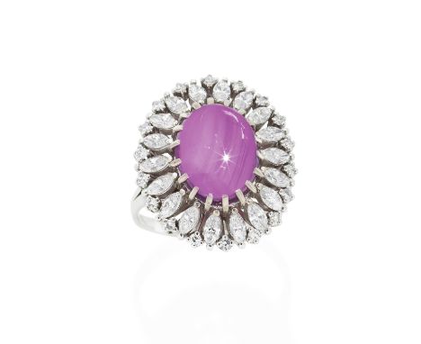 RUBY AND DIAMOND RINGThe cabochon ruby, weighing 6.61 carats, within a surround of marquise and single-cut diamonds, ring siz