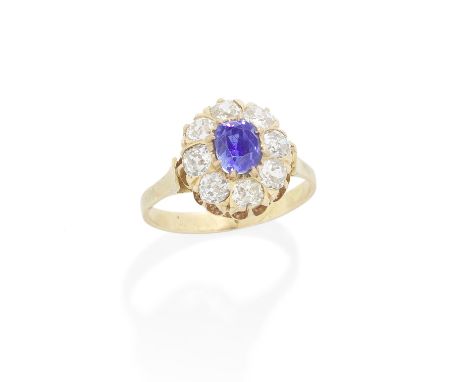 SAPPHIRE AND DIAMOND CLUSTER RING, LATE 19TH CENTURYThe cushion-shaped sapphire, weighing 1.45 carats, within a surround of c