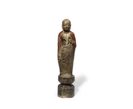 A RARE LARGE POLYCHROMED LIMESTONE FIGURE OF A LUOHAN9th/10th centurySubtly carved standing forward with his gaze downcast in