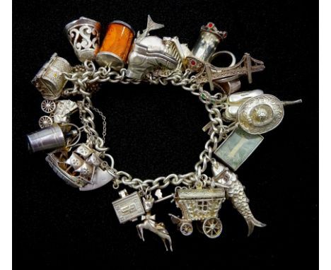 Silver charm bracelet with twenty six charms including clock, hedgehog, shark, treasure chest and Bible, hallmarked or tested