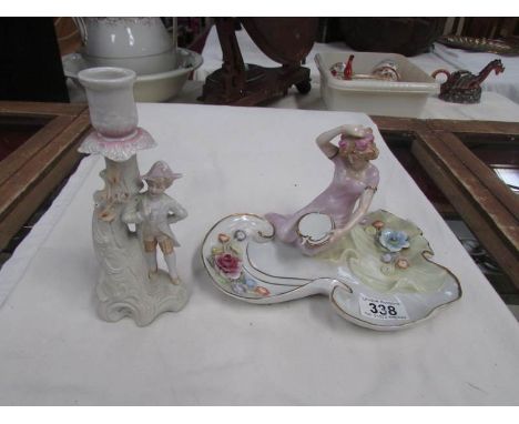 A German porcelain dish surmounted figurine and a continental porcelain figural candlestick.