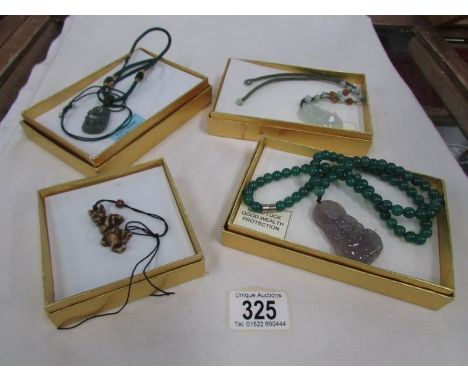 3 jade pendants depicting Buddha's and a rabbit pendant.