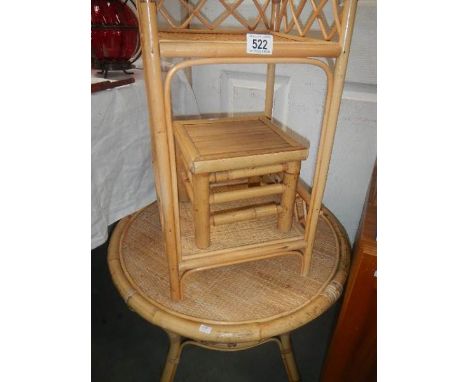 A bamboo circular table, a bamboo 2 shelf unit and a small bamboo stool.