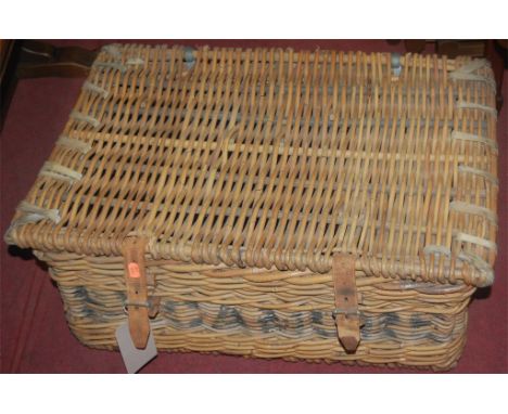 A wicker hinged top picnic hamper