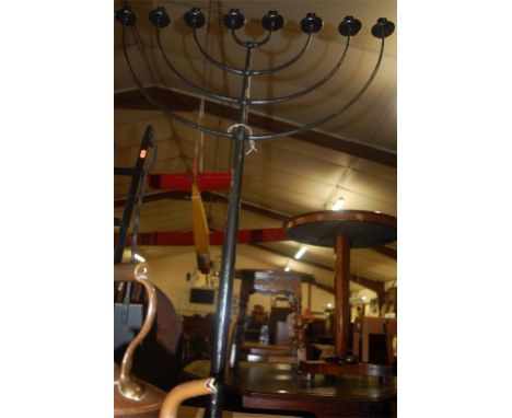 A black painted wrought iron eight branch freestanding candlestick retailed by Boden, together with a copper and brass range 