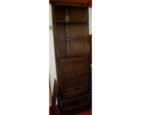 A contemporary Ercol dark elm freestanding corner cupboard, having lower cupboard door; together with an Ercol dark elm TV an