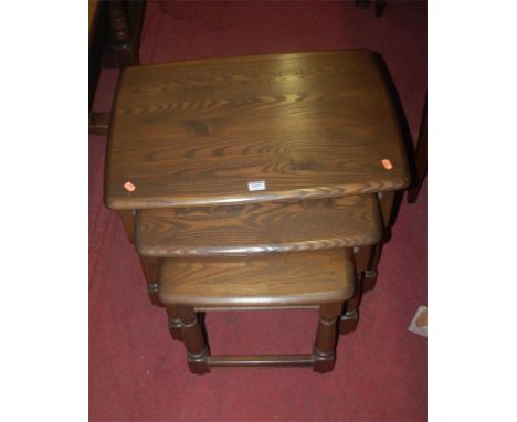 A contemporary Ercol mid-elm nest of three occasional tables 