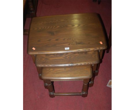 A contemporary Ercol mid-elm nest of three occasional tables 