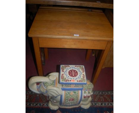 A 1950s beech hinge top child's school desk, together with a glazed ceramic Indian elephant seat (2)