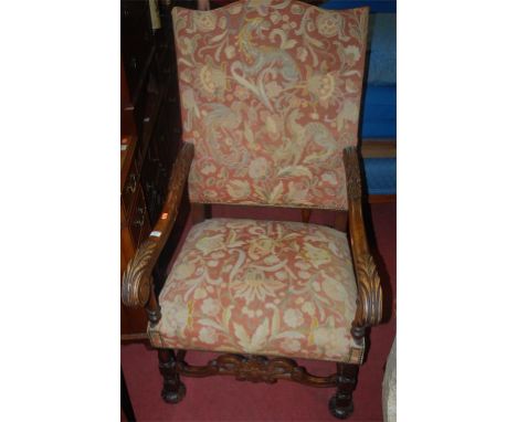 An early 20th century carved walnut framed floral tapestry upholstered and further studded armchair, in the 17th century styl