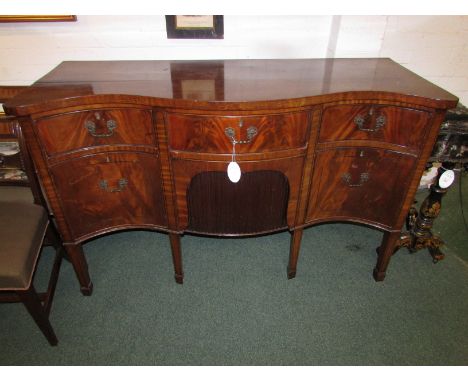 An early 19th century serpentine fronted Regency style sideboard, the top with three drawers, a central deep drawer with reed