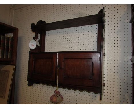 A mahogany wall bracket with shelf over two door enclosed cupboard, the side supports with simple fret work, and zigzag shape