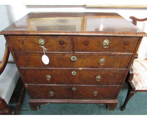 An early George III mahogany chest of two short over three long graduated drawers on bracket feet. The quarter veneered top h