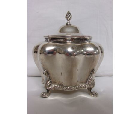 And Edwardian silver tea caddy of persimmon shape standing on four paw feet, hinged lid with finial, marks for Chester, 1907,