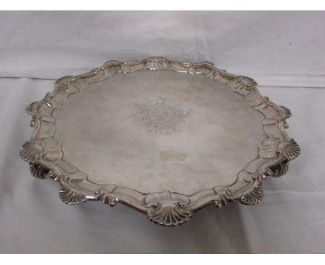 George II silver salver, circular with scalloped border standing on three scrolled feet, engraved to the centre with coat of 