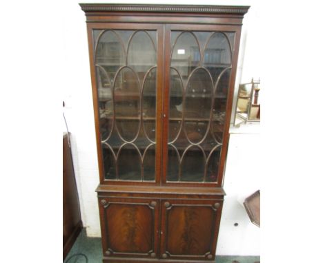 Dark mahogany bookcase, overall in the Regency style, the upper glazed section with four adjustable shelves (one incomplete),