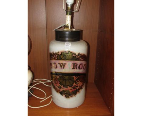 A cylindrical glass apothecary jar converted to electric table lamp, the jar whitened within and titled in gilt ARROW ROOT wi