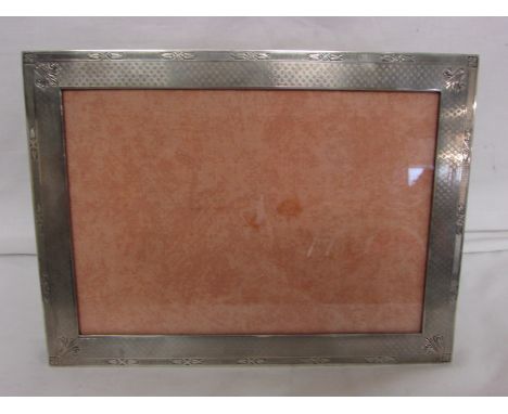 White metal rectangular photograph frame, engine turned border with floral motifs at intervals, (overall 16.8cm x 22.6cm, ape