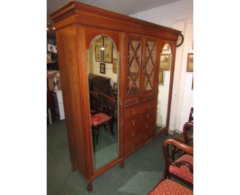 A large Waring & Gillow oak compactum, the central section with a glazed two door cupboard to top with lozenge mullions over 