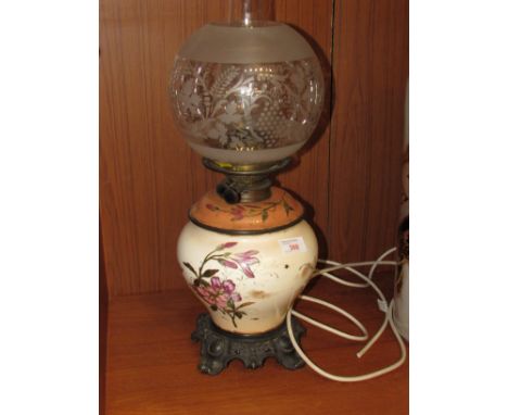 19th century oil lamp converted to electricity with baluster pottery body painted with flowers and birds mounted on a scrolle