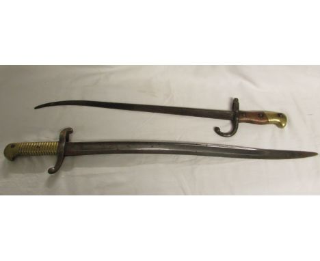 Two sword bayonets, probably French, the first with a quillon stamped with marks and numbers and a brass and wooden handle (o