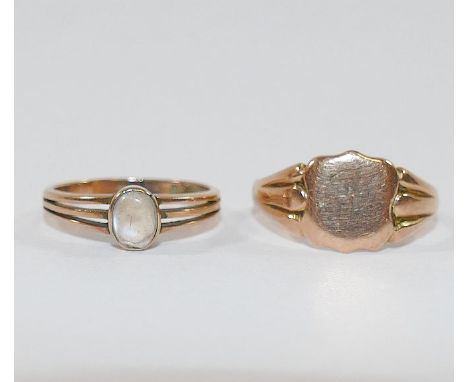 A yellow metal moonstone single stone ring, stamped '9', 2g gross, finger size K 1/2 and a yellow metal signet ring, with ins