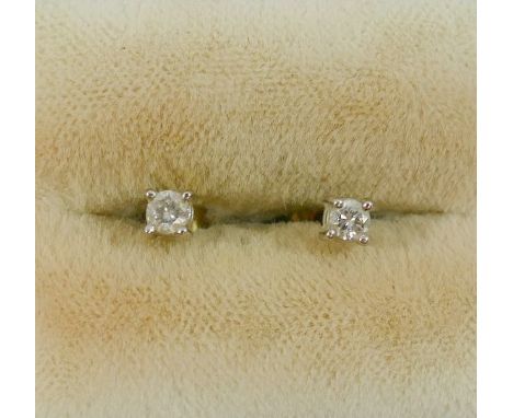 A pair of small diamond stud earrings, each round brilliant cut stone approximately 0.15 carats, housed in four claw settings