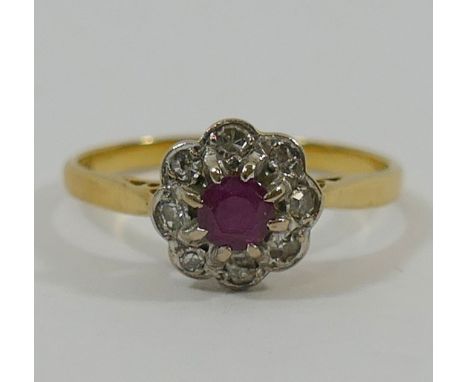 A ruby and diamond circular daisy head cluster ring, the circular mixed cut ruby within eight small diamond surround the eigh