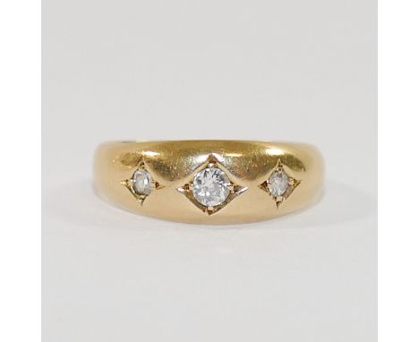 An Edwardian 18 carat gold diamond gypsy set three stone ring, the graduated old cut stones combined weight approximately 0.2