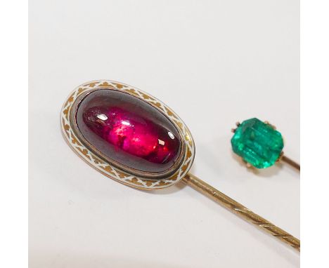 A late 19th century gold, garnet and white enamel stick pin, 7.6cm long, and another gold stick pin set with green paste stam