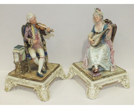 A pair of 19th century Royal Dux Bohemia porcelain figures of seated musicians playing a violin, (bow missing) and a lute, pr