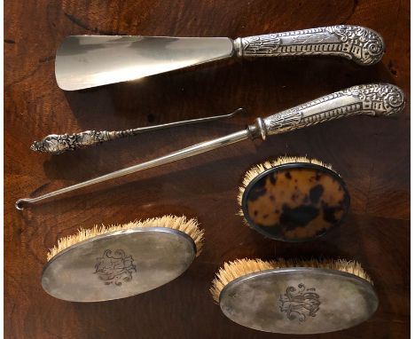 Two brushes, shoe horn and two button hooks all with silver mounts and another brush