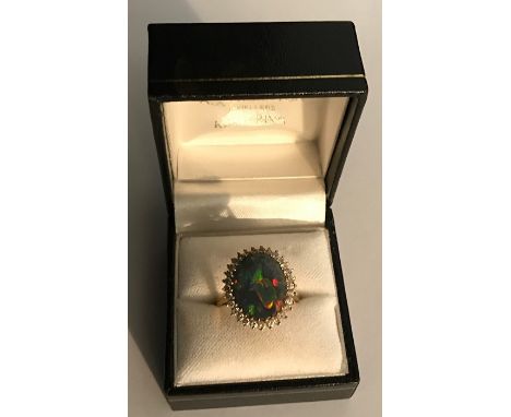 Black opal and diamond cluster ring set in 18ct yellow gold, opal 15mms x 11mms.