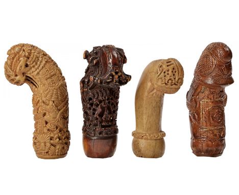 A lot of four kris hilts dating: circa 1900 provenance: Indonesia Richly carved, horn hilts, one with helmet and epaulets of 