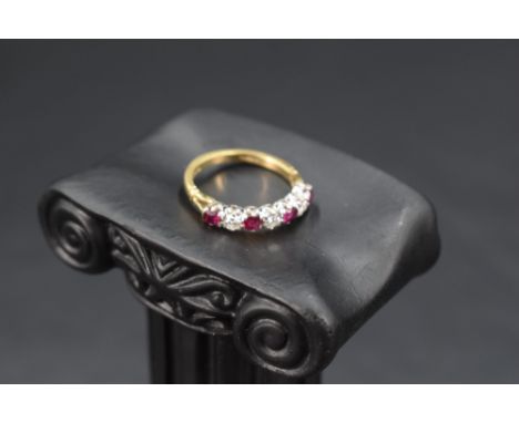 A seven stone ruby and diamond half eternity ring, each stone approx 0.064ct in a claw set mount on an 18ct gold loop, size L